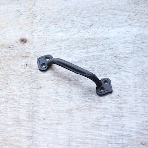 Pode incluir: Puxador de porta de metal preto com design curvo e extremidades quadradas.