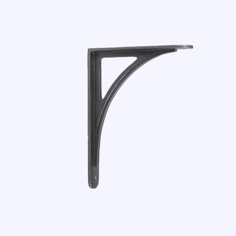 May include: A dark gray, cast iron shelf bracket with a curved support and a triangular cutout. The bracket has a flat top for supporting a shelf and a hole for mounting. The overall design is simple and functional.