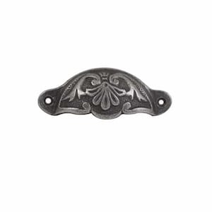 May include: A silver-toned metal drawer pull with an ornate floral design. The pull is shaped like a half-circle and has two small holes for mounting.