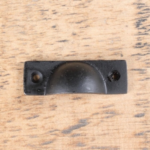 May include: Black metal cabinet pull with a rounded top and two screw holes.