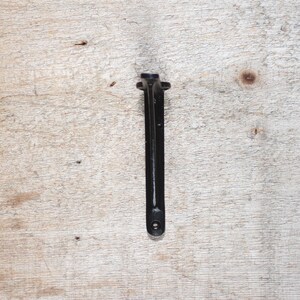 May include: Black metal shelf bracket with a simple design. The bracket is made of sturdy metal and has a smooth, black finish.