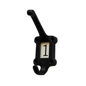 May include: Black metal coat hook with a numbered tag. The tag has the number "1" printed on it in white.
