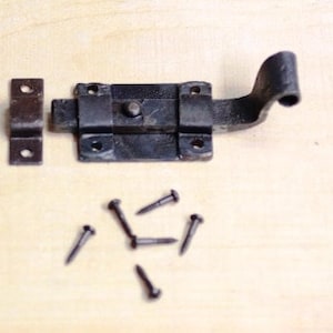 May include: Black metal door latch with a curved handle and a separate strike plate. The latch comes with eight small black screws.
