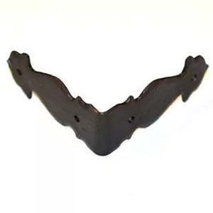 May include: Black metal corner brace with a decorative design. The brace has a V-shape and is made of metal.