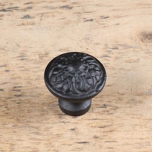 Peut inclure: Bouton de porte en fonte noire avec un motif floral.