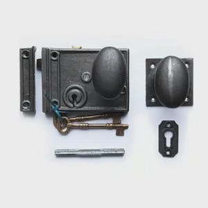 May include: A dark grey vintage door lock set, featuring an oval doorknob and backplate. The set includes a latch, strike plate, and two ornate keys. A silver screw and keyhole cover are also included.