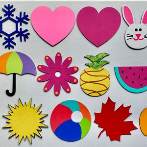 May include: A set of 14 felt cutouts representing different seasons and holidays. The cutouts include a snowman, snowflake, heart, bunny, Easter egg, umbrella, flower, pineapple, watermelon, sun, beach ball, leaf, and pumpkin.