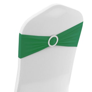May include: A green chair sash with a silver buckle. The sash is tied around a white chair.