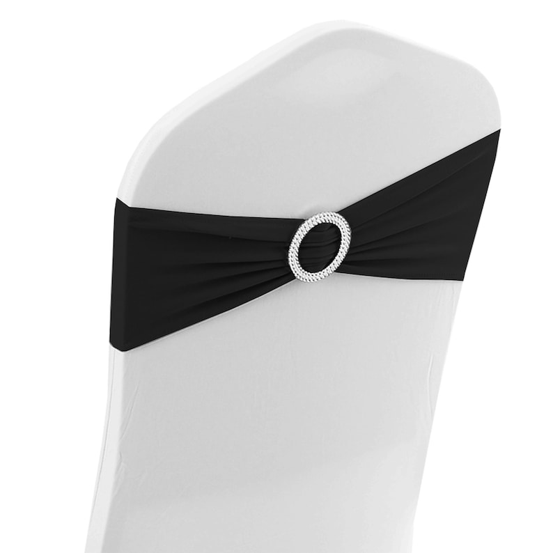 May include: Black chair sash with a rhinestone buckle. The sash is tied around the back of a white chair.