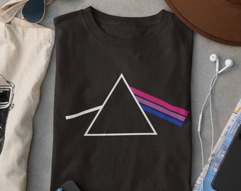 Puede incluir: Una camiseta negra con un triángulo blanco y un diseño de prisma de arcoíris. El arcoíris está en los colores de la bandera del orgullo bisexual.