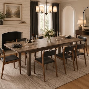 May include: A rectangular wooden dining table with a natural grain finish, accompanied by six chairs featuring dark brown wooden frames and black upholstered seats, arranged in a dining room setting with a fireplace and a chandelier.