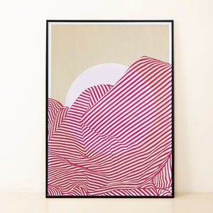 May include: A framed print of a pink and white striped abstract design. The design resembles a mountain range with a white circle in the background.