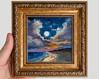 May include: An oil painting of a moonlit seascape at night, featuring a bright white moon in a dark blue and purple cloudy sky above a dark shoreline and reflective water, encased in an ornate, textured, metallic gold-toned wooden frame.