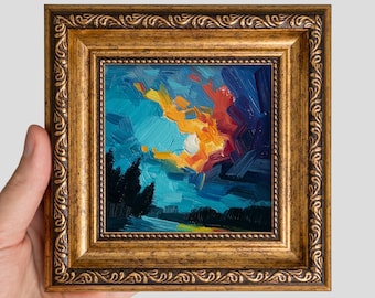 May include: A small square oil painting featuring a vibrant sunset with thick brushstrokes of yellow, orange, and red against a deep blue sky, set within an ornate, antique-style gold frame with intricate embossed patterns along the edges.