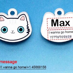 May include: White cat-shaped pet ID tag with a blue background. The tag has the name "Max" and the text "I wanna go home!" with a phone number.