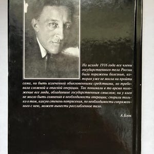 May include: A black book cover featuring a portrait of a man in a suit and tie. The book has text in Russian on the back cover, with the author's name, A. Blok, at the bottom. The cover is glossy and reflects light.