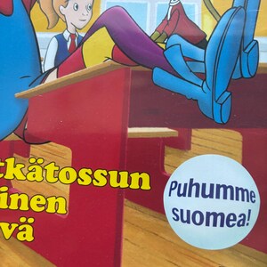 May include: DVD case featuring cartoon illustrations of a girl, a monkey, and a boy. The monkey wears a hat and red jacket. The text "Puhumme suomea!" is on a blue circle. The DVD logo is at the bottom.