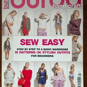 Op de afbeelding: Een tijdschriftcover met de titel "burda handicraft" in roze. De cover toont meerdere afbeeldingen van vrouwen in verschillende outfits. De tekst "SEW EASY" en "STEP BY STEP TO A BASIC WARDROBE" staat prominent, wat duidt op naaipatronen voor beginners.