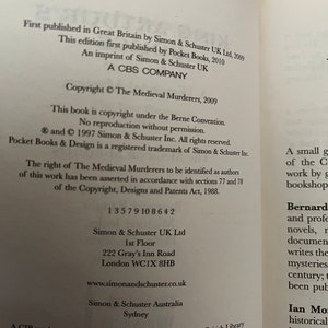 May include: An open book page displaying text from "The Medieval Murderers" by Simon & Schuster. The page includes copyright details, ISBN, and publisher information. Black text on a white page.