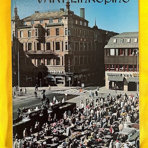 May include: A vintage book cover titled "Vårt Linköping" featuring a photograph of a city square with a bustling market, buildings, and people. The cover has a blue background with the title in black.