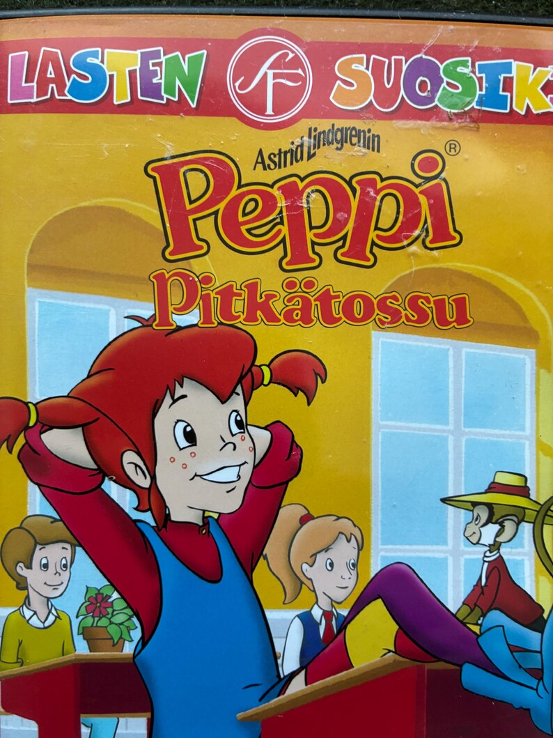 May include: A DVD case featuring the animated character Pippi Longstocking. The cover has a yellow background with the title "Peppi Pitk&auml;tossu" in red and yellow lettering. The image shows Pippi with red pigtails, a blue dress, and other cartoon characters.
