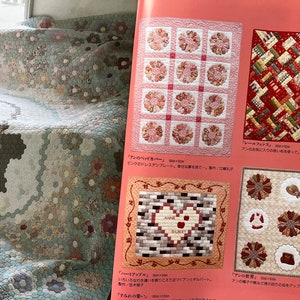 May include: A page from a craft book showcasing various handmade quilts. The quilts feature floral and geometric patterns in soft pastel colors. One quilt has a basket design, while others display intricate patchwork and appliqué techniques.