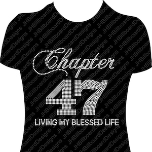 May include: Black t-shirt with rhinestone embellishments that spell out "Chapter 47 Living My Blessed Life".