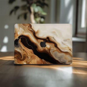 May include: Laptop case with a swirling abstract design in shades of brown, black, and cream. The case features the Apple logo in black. The design resembles marble or flowing paint.
