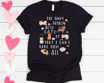 May include: Black t-shirt with a white graphic that says "The only problem with cats is that I can't have them all". The graphic features several cartoon cats with different colored fur and accessories.