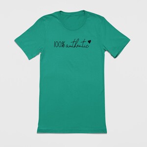 May include: A teal green t-shirt with the text "100% authentic" and a small black heart.