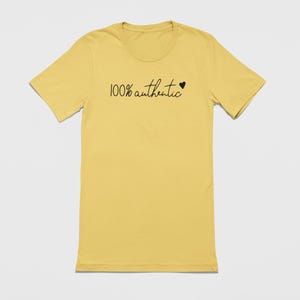 May include: A yellow t-shirt with the text "100% authentic" and a small heart.
