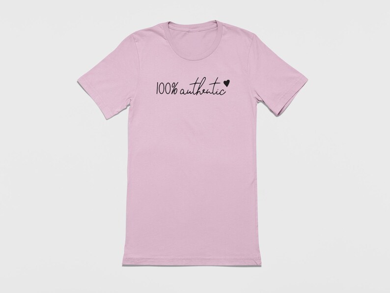 May include: A light pink t-shirt with the text "100% authentic" and a small black heart.
