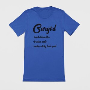 May include: A royal blue t-shirt with black text that reads "Cargirl - busted knuckles - broken nails - makes dirty look good".