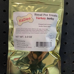 May include: A gold resealable bag of KaDee Turkey Jerky pet treats. The bag is labeled with the product name, ingredients, net weight, and distribution information. The bag has a barcode and a Wisconsin Department of Agriculture inspection sticker.