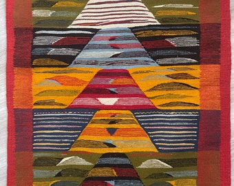May include: A colorful woven wall tapestry with a geometric design featuring multiple triangles and stripes in shades of red, yellow, blue, green, and white.