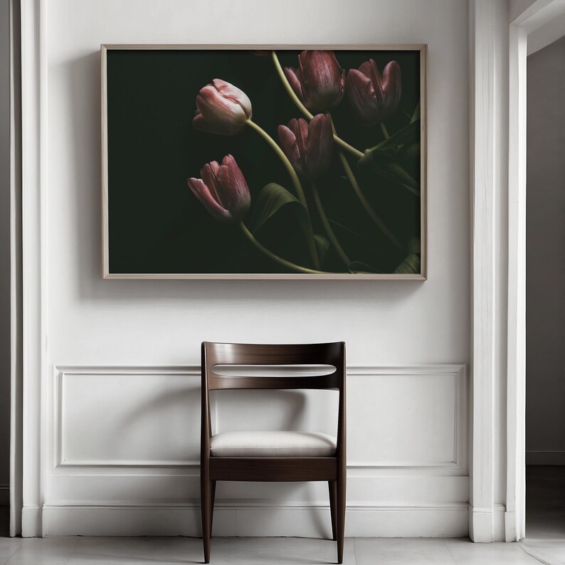 May include: A framed photograph of a bouquet of pink tulips against a dark background. The tulips are arranged in a loose, natural style, with some of the stems crossing over each other. The image is in a muted color palette, with the pink tulips standing out against the dark background.