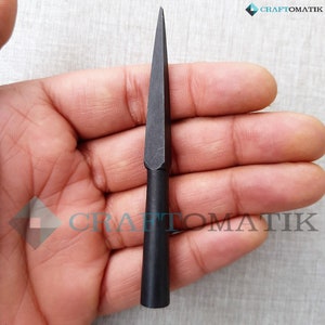 May include: A black metal arrowhead with a sharp point and a long, slender shaft.