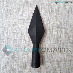 May include: A black metal spearhead with a sharp point and a cylindrical shaft.