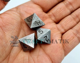 May include: Three metal dice with a pyramid shape and a textured surface. The dice are numbered 4, 5, and 6. The dice are in a hand.