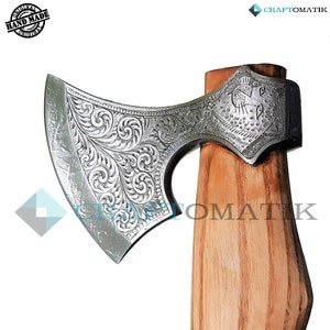 May include: A silver axe with an intricate floral design and a wooden handle. The axe head has a wolf design on the back.