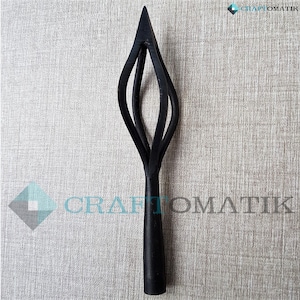 May include: A black metal decorative spear with a pointed top and a spiraling design. The spear has a long, cylindrical handle. The Craftomatik logo is visible in the upper right and lower center.