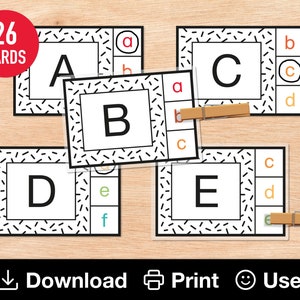 May include: A set of 26 alphabet letter cards with a black and white geometric pattern. Each card features a letter in a white square with a black outline. The letters are A, B, C, D, and E.