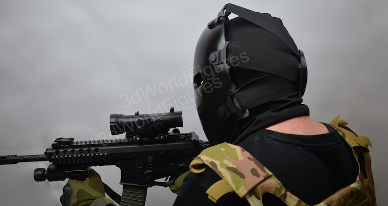 May include: A person wearing a black tactical helmet and a camouflage vest holds a black rifle with a scope.