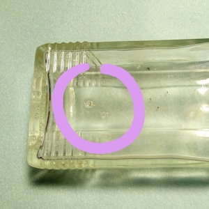 Vintage bottle with rare imperfection: thread of glass through center