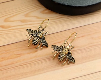 Bi-örhängen, insekter och kryp, egyptisk-inspirerade minimalistiska smycken.