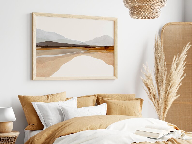 May include: A bedroom with a bed dressed in beige linens and a framed abstract landscape painting above the headboard. The room features a woven headboard and a dried pampas grass arrangement in a woven vase.