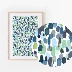 Puede incluir: Pintura abstracta de acuarela con fondo blanco y un patr&oacute;n de puntos azules, verdes y grises. La pintura est&aacute; enmarcada en un marco de madera claro.