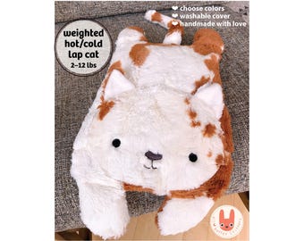 May include: A plush weighted cat toy with white and brown fur, featuring embroidered black eyes and a nose. Text on the image reads: weighted hot/cold lap cat 2-12 lbs, choose colors, washable cover, handmade with love. The cat has a long tail.
