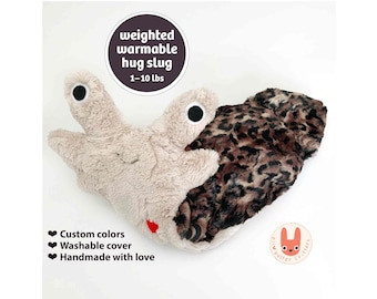 May include: A plush slug toy with a beige head featuring two black and white eyes and a brown and black leopard print body. Text reads: weighted warmable hug slug 1-10 lbs, Custom colors, Washable cover, Handmade with love, and all better critters.