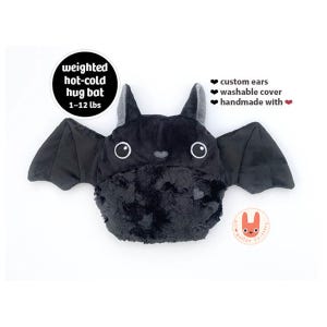 May include: A black plush bat toy with large white eyes, pointed ears, and a textured belly. Text reads: weighted hot-cold hug bat 1-12 lbs, custom ears, washable cover, handmade with heart. A small orange rabbit logo is visible in the corner.